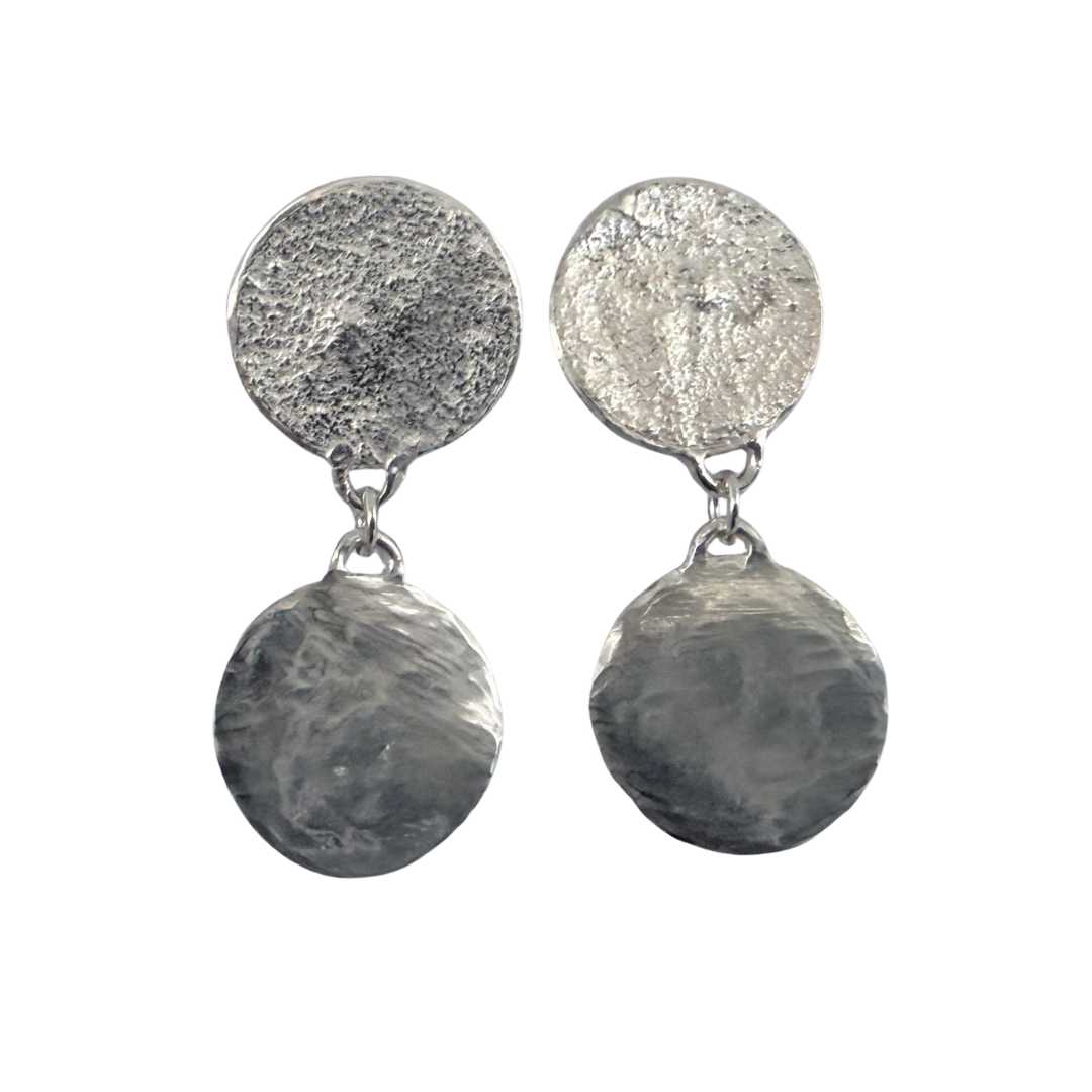 Clear front view of a pair of sterling silver Sequin Disc Dangle Earrings without backings on a seamless white background, emphasising the contrast between the reticulated stud and polished drop disc.