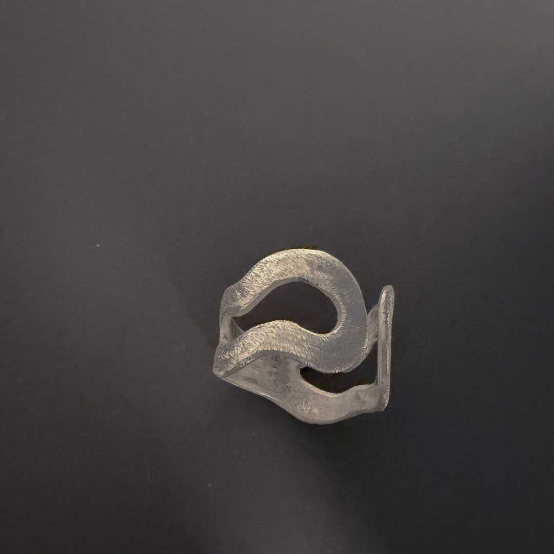 Finished handmade sterling silver split ring photographed against a black background