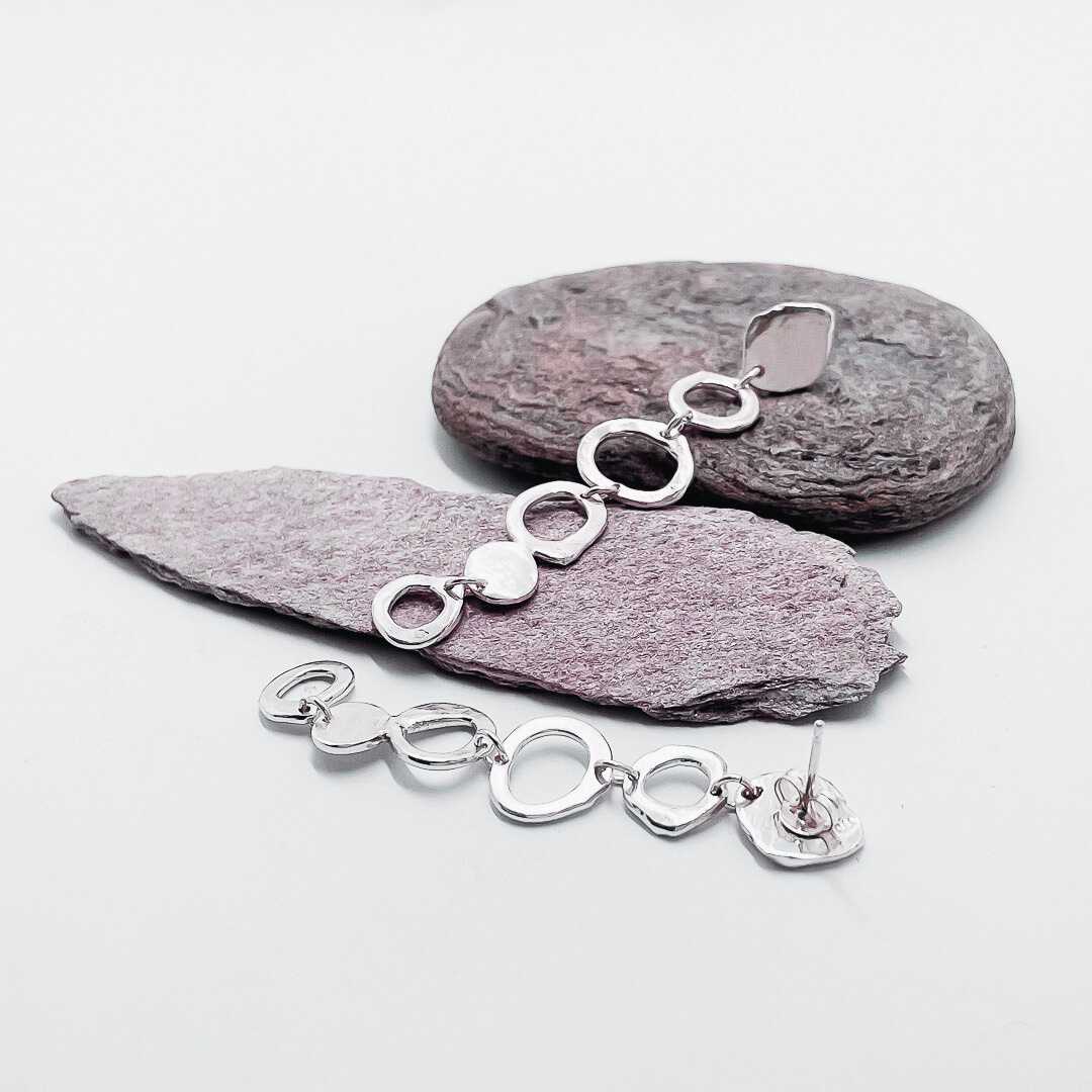 Organic Circle Trail Earrings in sterling silver by Sally Herbert, displayed on textured stones showing front and back details of the kinetic drops.
