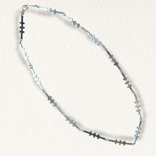 Handcrafted sterling silver Talisman Necklace with irregular sculptural links on a soft textured paper background.