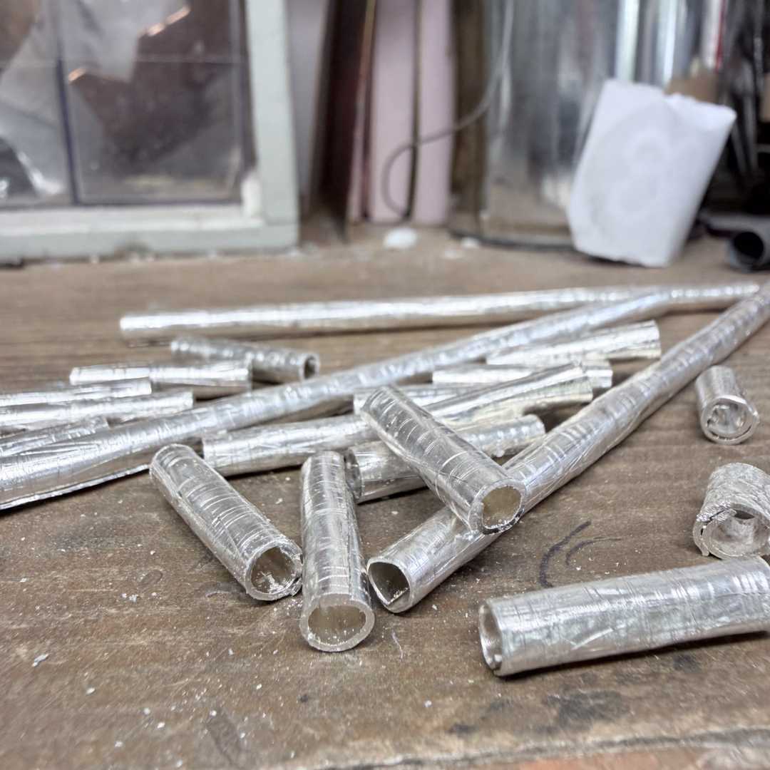 Wrapped fine silver beads in progress with rough edges, showing handmade jewellery process