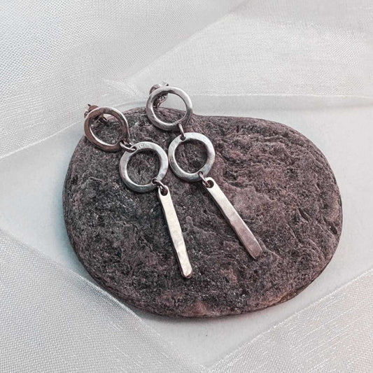 Abstract Circle Earrings No. 25 in sterling silver resting on a textured stone, surrounded by soft white organza ribbon, handcrafted by HerbertandWilks