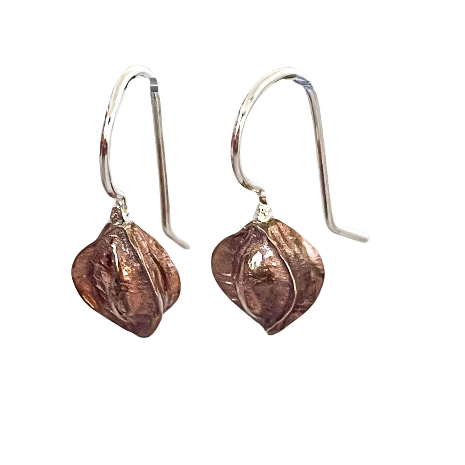 Kowhai pod drop earrings on white background tilted to show bronze edge detail and hand-forged thickness