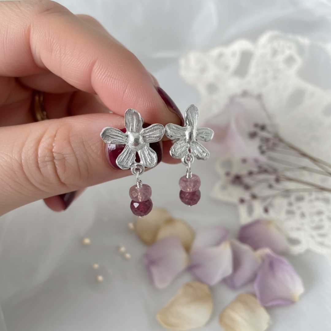 Flora Drop Earrings with Pink Tourmaline – close-up of handcrafted sterling silver flower studs with faceted pink tourmaline gemstone drops