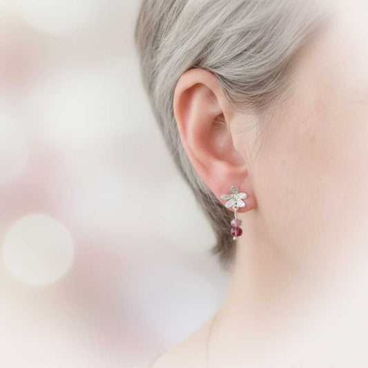 Flora Drop Earrings with Pink Tourmaline being worn – showing delicate sterling silver flower studs with pink tourmaline drops on ear