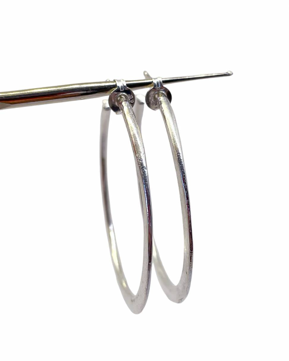 A pair of Sterling Silver Lunar Hoops showing how the front of the hoop sharpens to a knife edge