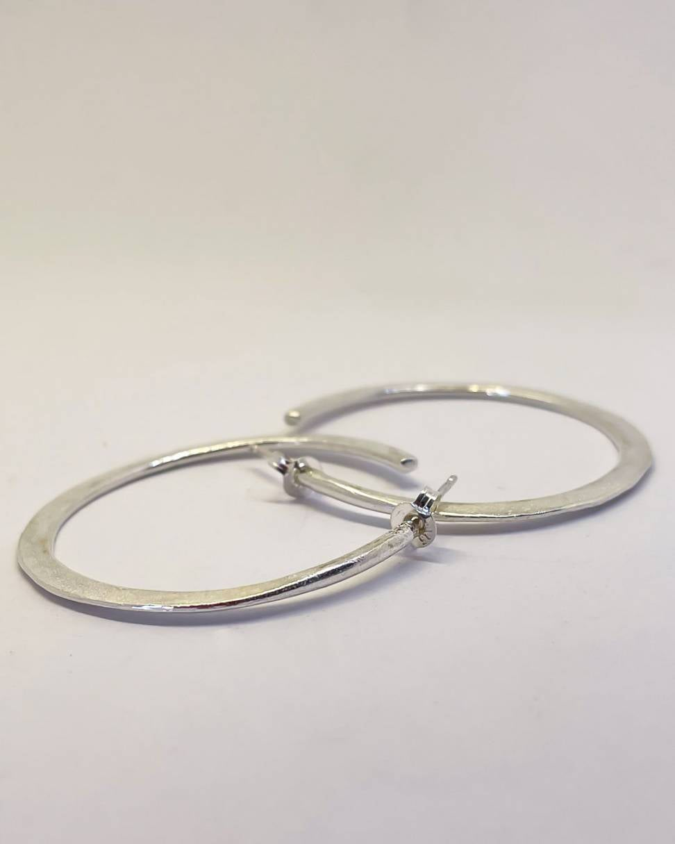 A pair of Sterling Silver Lunar Hoops showing the top of the hoop earrings