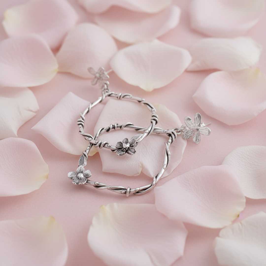 Sterling silver interwoven flora statement earrings styled on pale pink rose petals - romantic botanical wedding earrings handmade in New Zealand