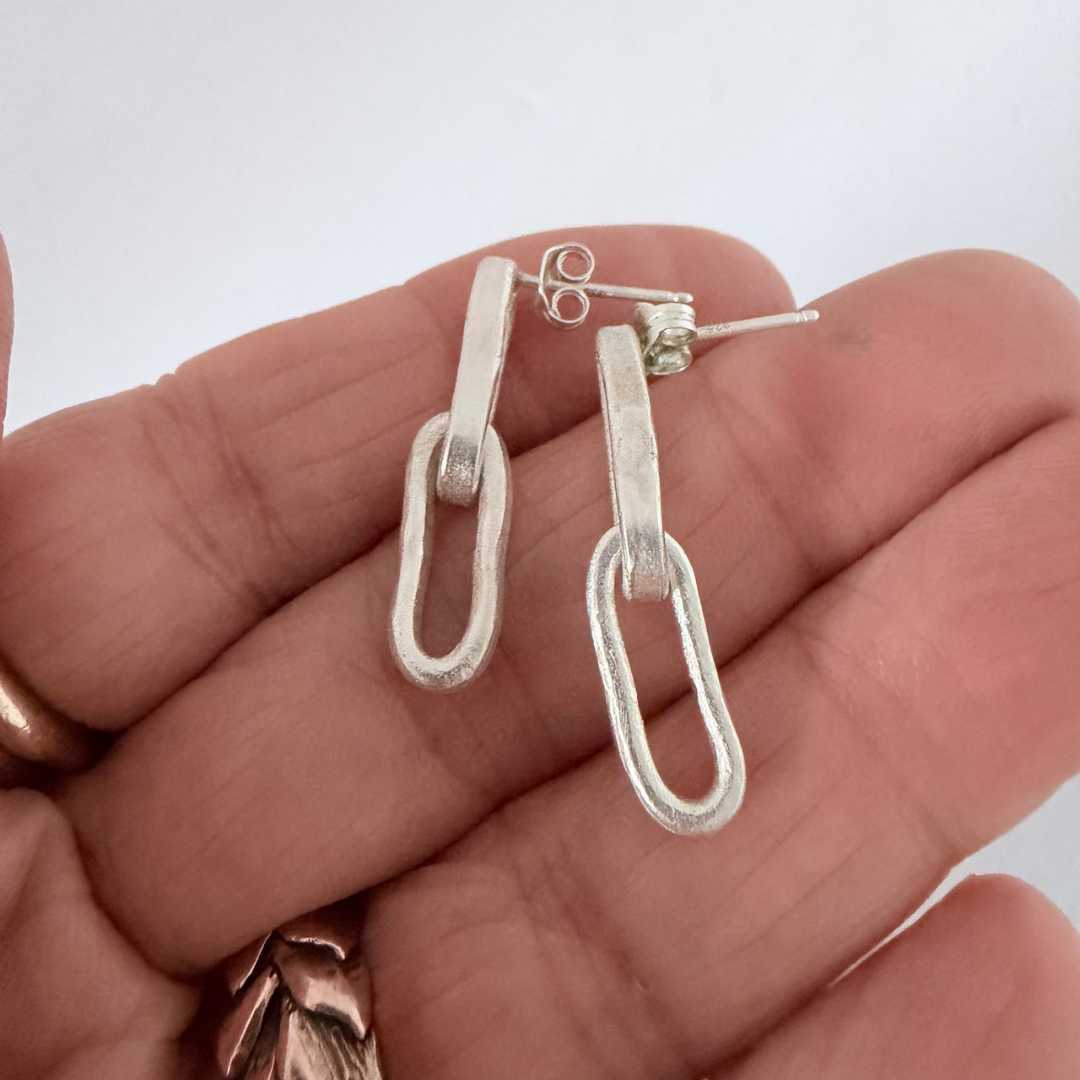 Paperclip Chain Link Earrings resting against a woman's fingers to show scale, sterling silver, 27mm length