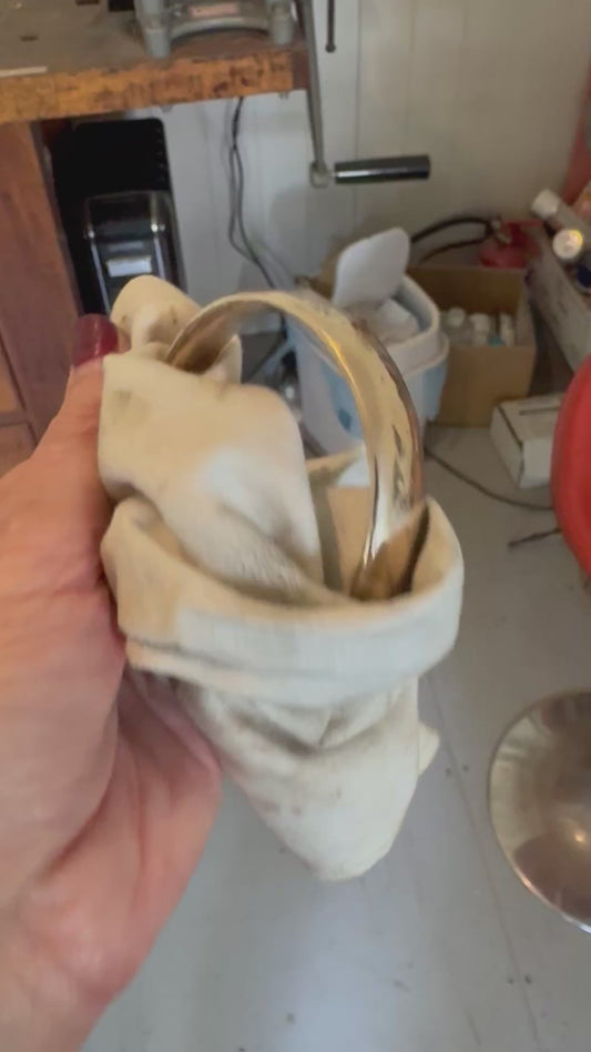 Handcrafted bronze bangle being polished in Auckland workshop - artisan jewellery making process