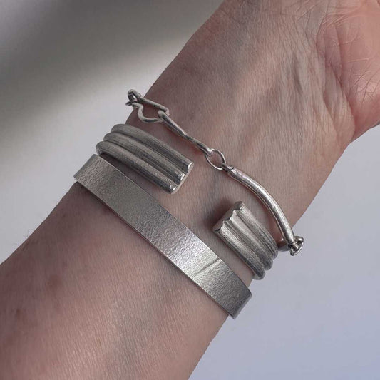 Three Line Cuff in sterling silver worn on the wrist, showing the open side and custom-fitted shape at the back of the wrist.