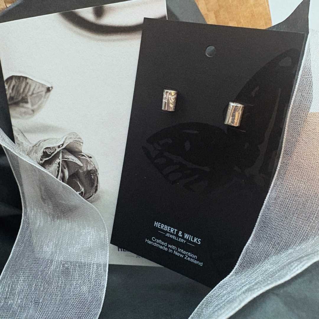 Close-up of fine silver Wrapped Mini Stud Earrings in gift box with HerbertandWilks card and soft white organza ribbon