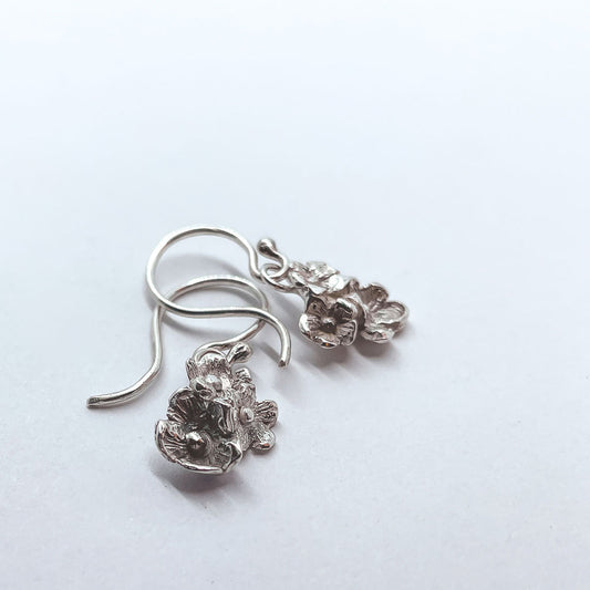a pair of Dangle earrings made of groupings of flowers