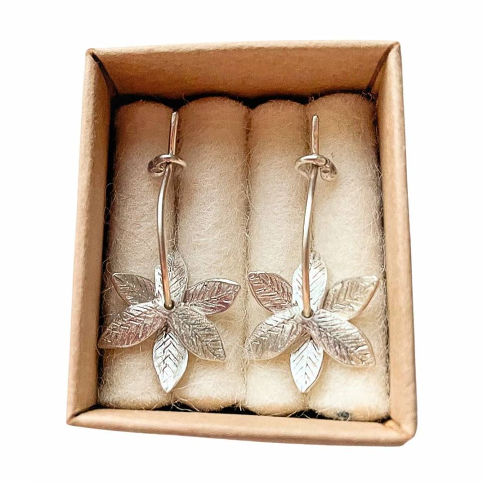A pair of Sterling Silver Fire-Star Flower Hoop Earrings shown in a presentation box