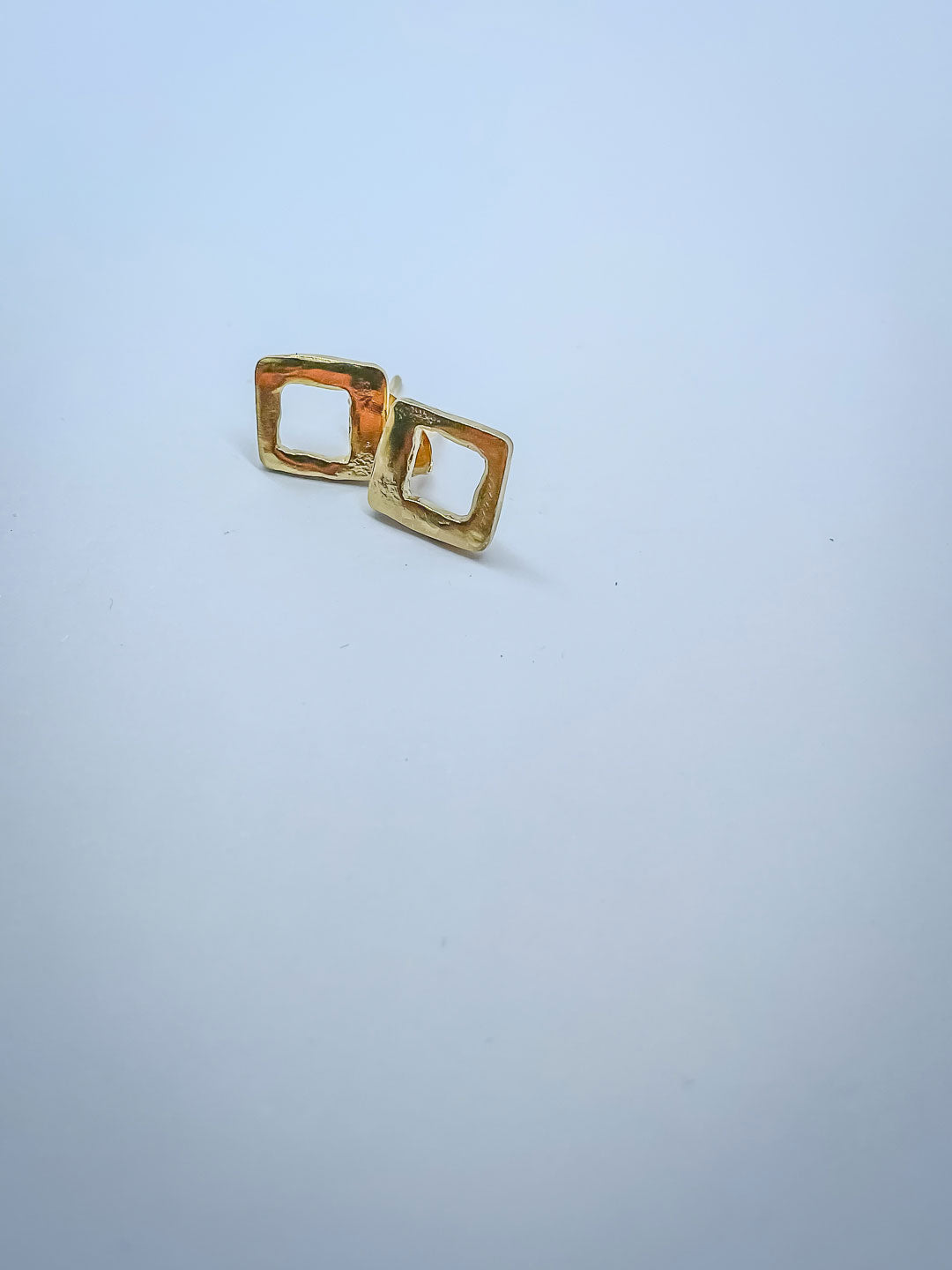 A pair of Gold open geometric form pierced earrings inspired by Mid Century Geometric Patterns. Deliberately left to show makers marks.