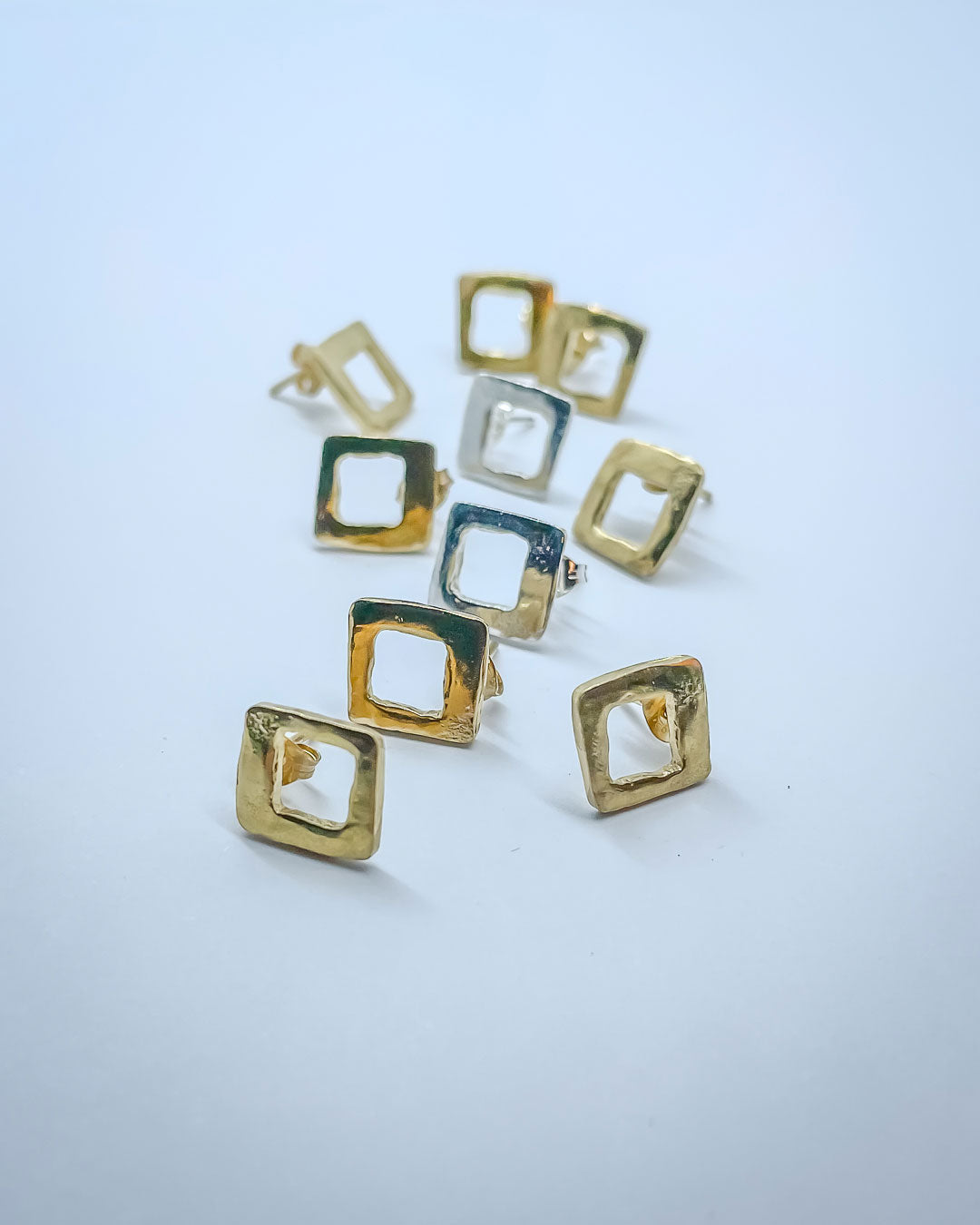 A scattering of Gold and Silver open geometric form pierced earrings inspired by Mid Century Geometric Patterns. Deliberately left to show makers marks.