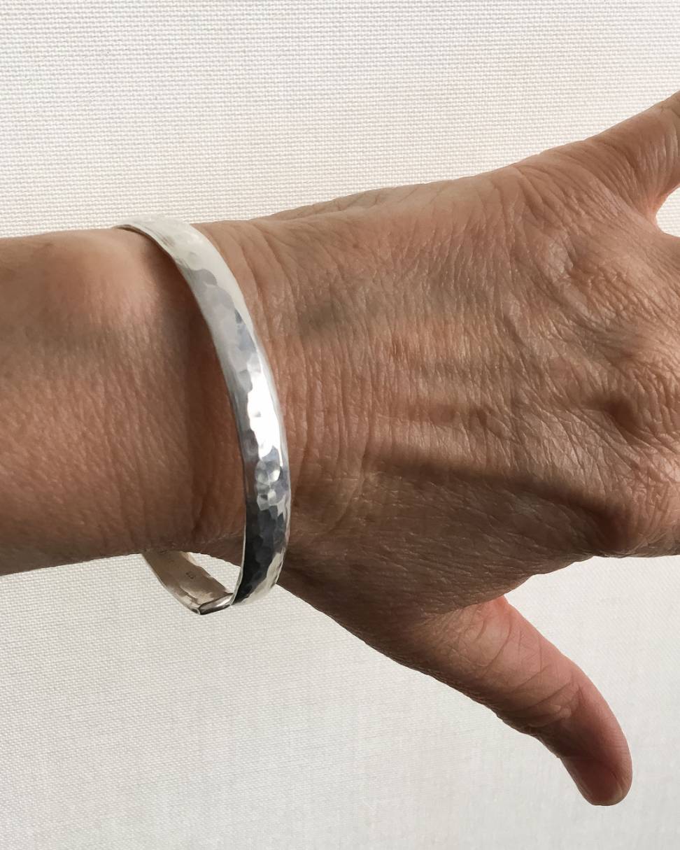 Hammered Textured Sterling Silver Oval Cuff Bangle worn on a wrist