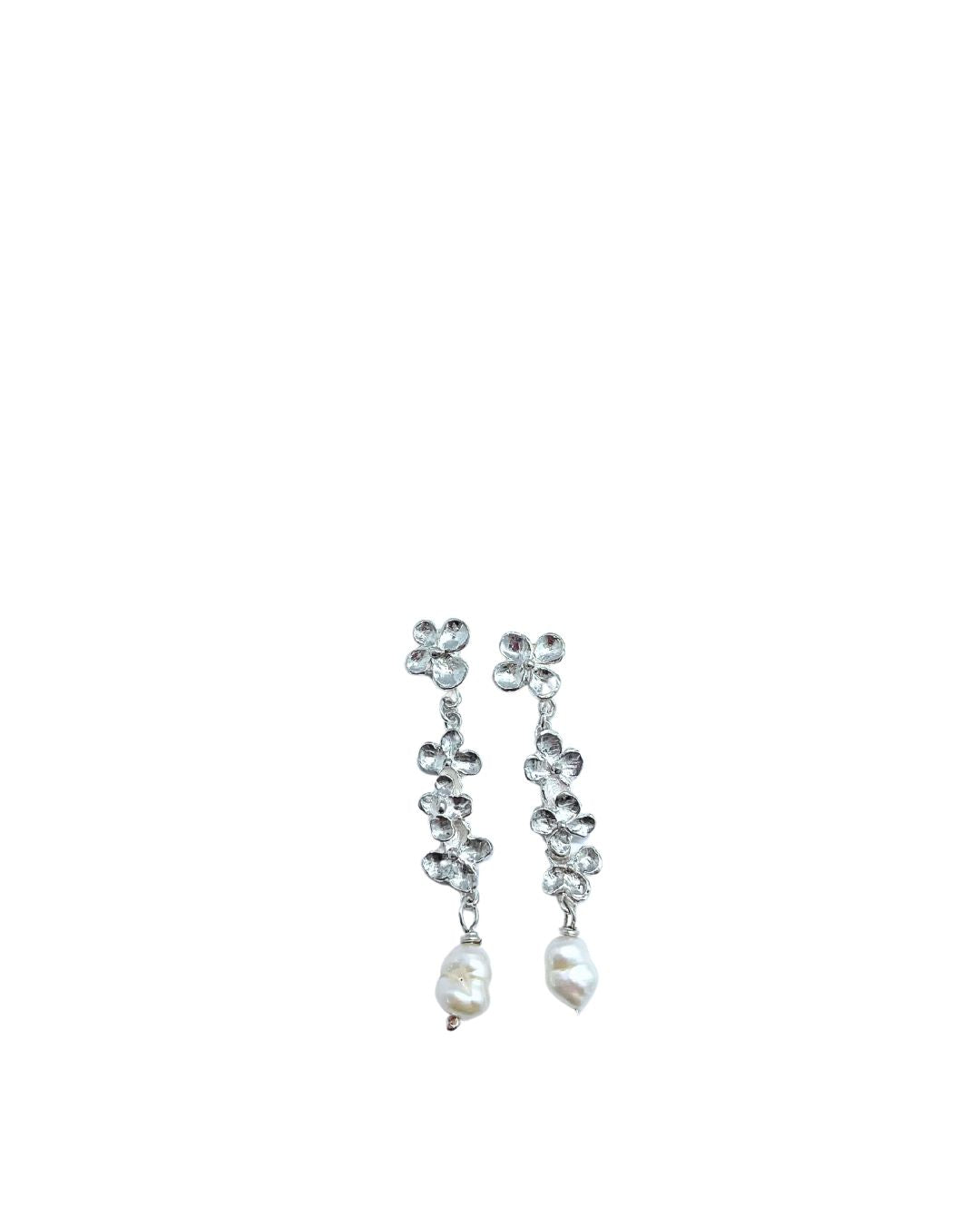 The front view of a pair of Hydrangea and Keshi Pearl Sterling Silver Dangle Earrings. A single Hydrangea flower Stud with three flowers hanging below with a Keshi Pearl dangle below the central flower trail.