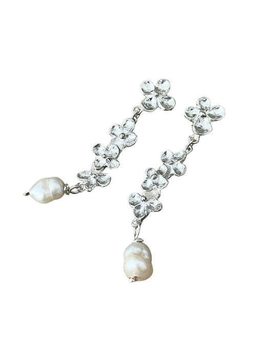 The front view of a pair of Hydrangea and Keshi Pearl Sterling Silver Dangle Earrings. A single Hydrangea flower Stud with three flowers hanging below with a Keshi Pearl dangle below the central flower trail.