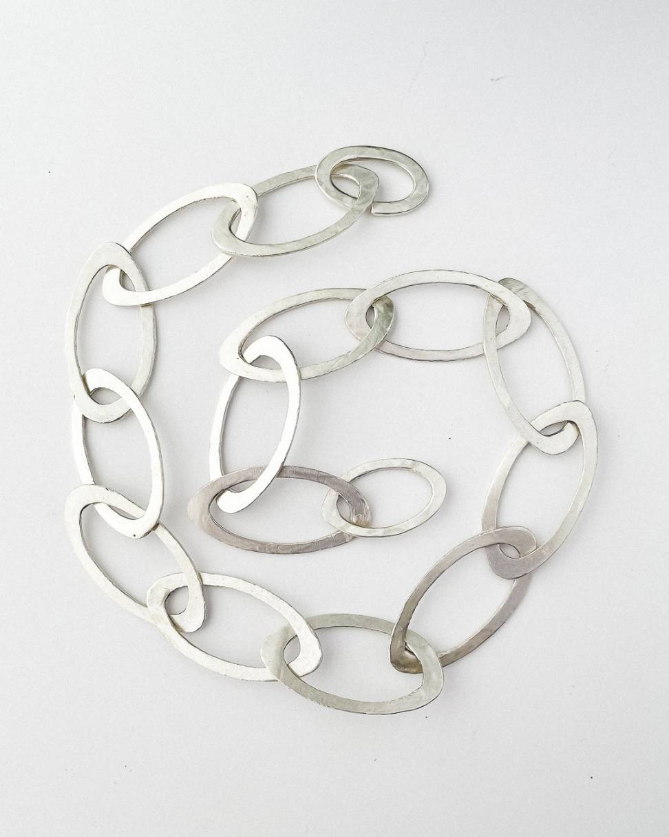 A hand fabricated Oval link chain in Sterling Silver laid in a spiral