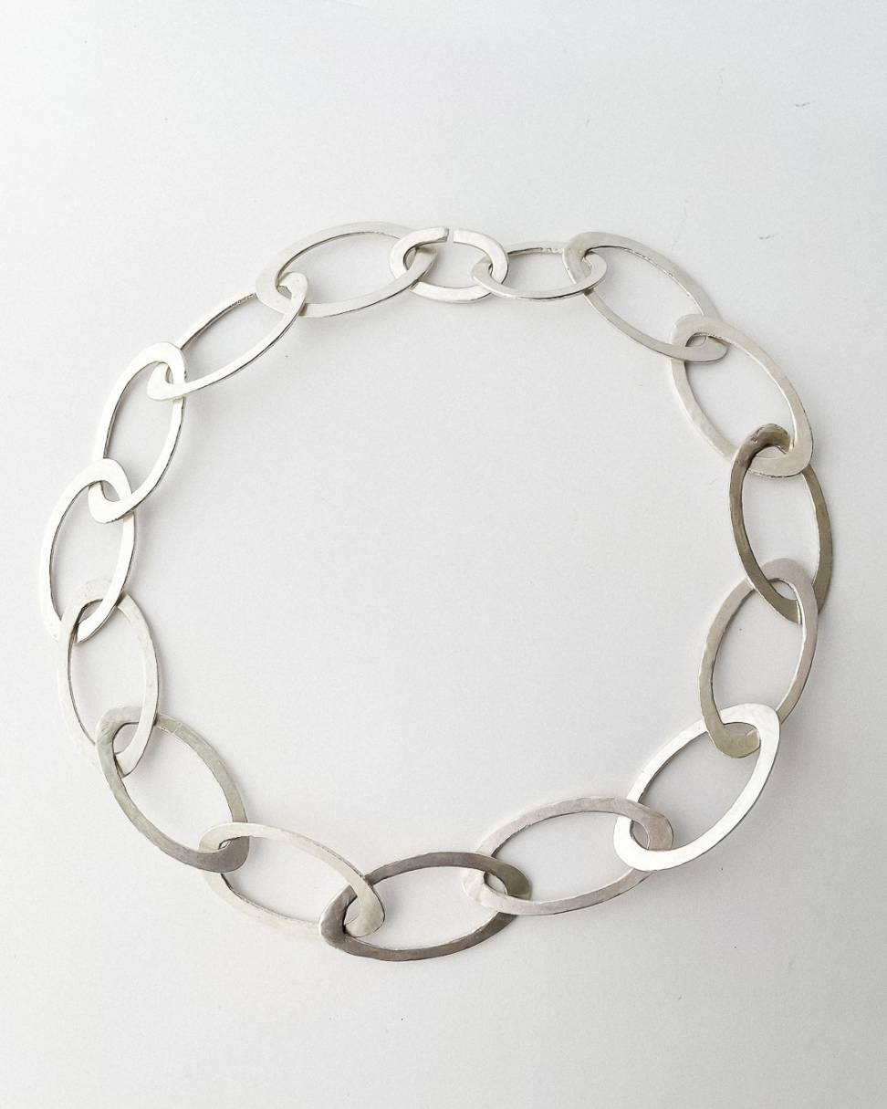 A hand fabricated Oval link chain in Sterling Silver laid in a circle