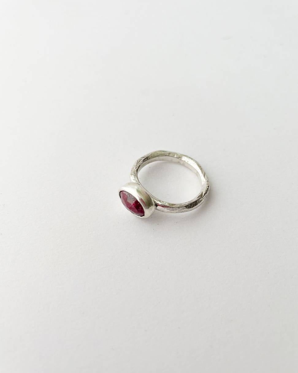 The side profile of an organic Sterling Silver ring set with a large faceted oval ruby