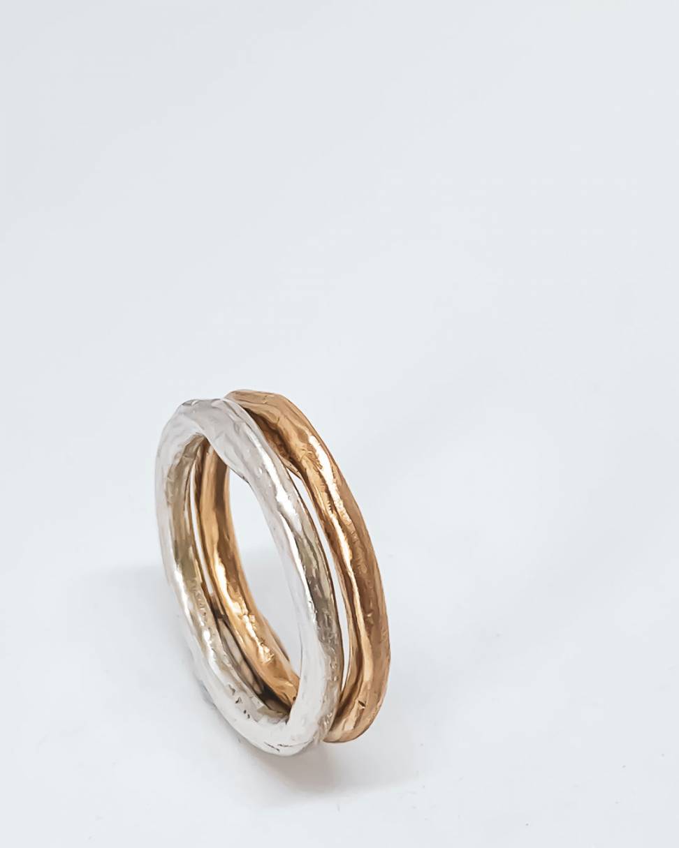 A pair of organic stacking rings one Sterling Silver and the other a golden bronze