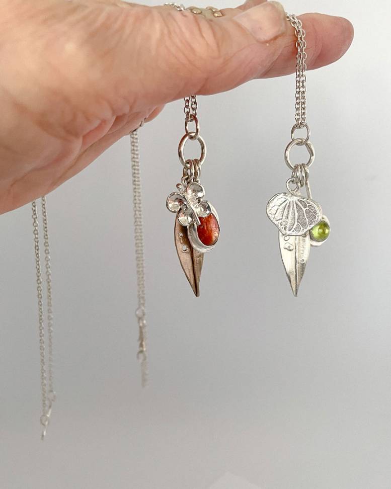 Two summer garden charm necklaces. One set with a Sunstone and the other set with a peridot. - showing the different charms making up each necklace