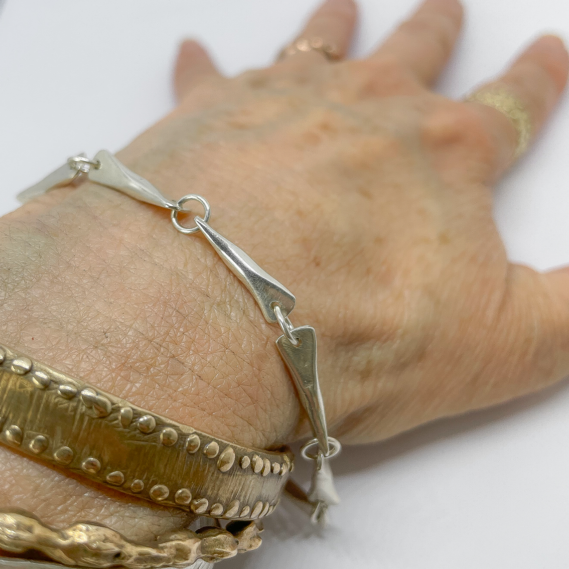 Hand wearing the Butterfly link chain and some bangles