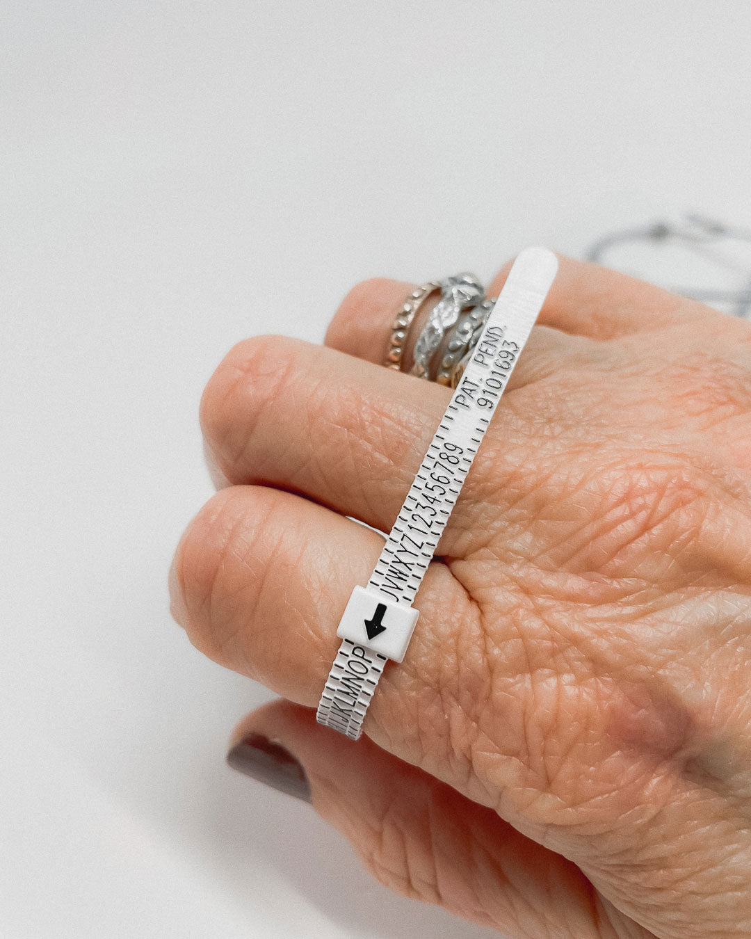 A hand with a Multisizer Ring tool wrapped around one finger