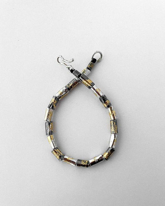 A beaded bracelet alternating between oxidised and plain silver decorated with 24ct Gold Leaf