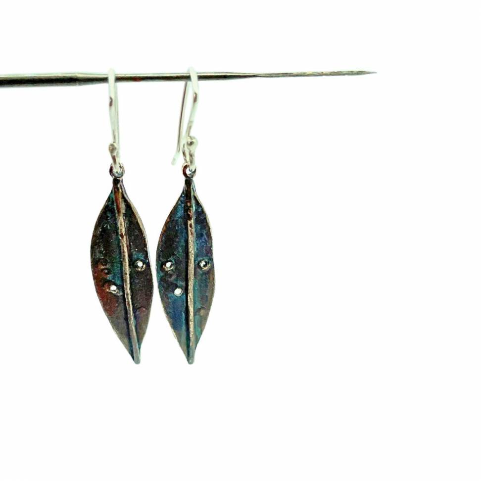 A pair of Bronze Pohutukawa Leaf Earrings hung from 925 Sterling Silver ear hooks