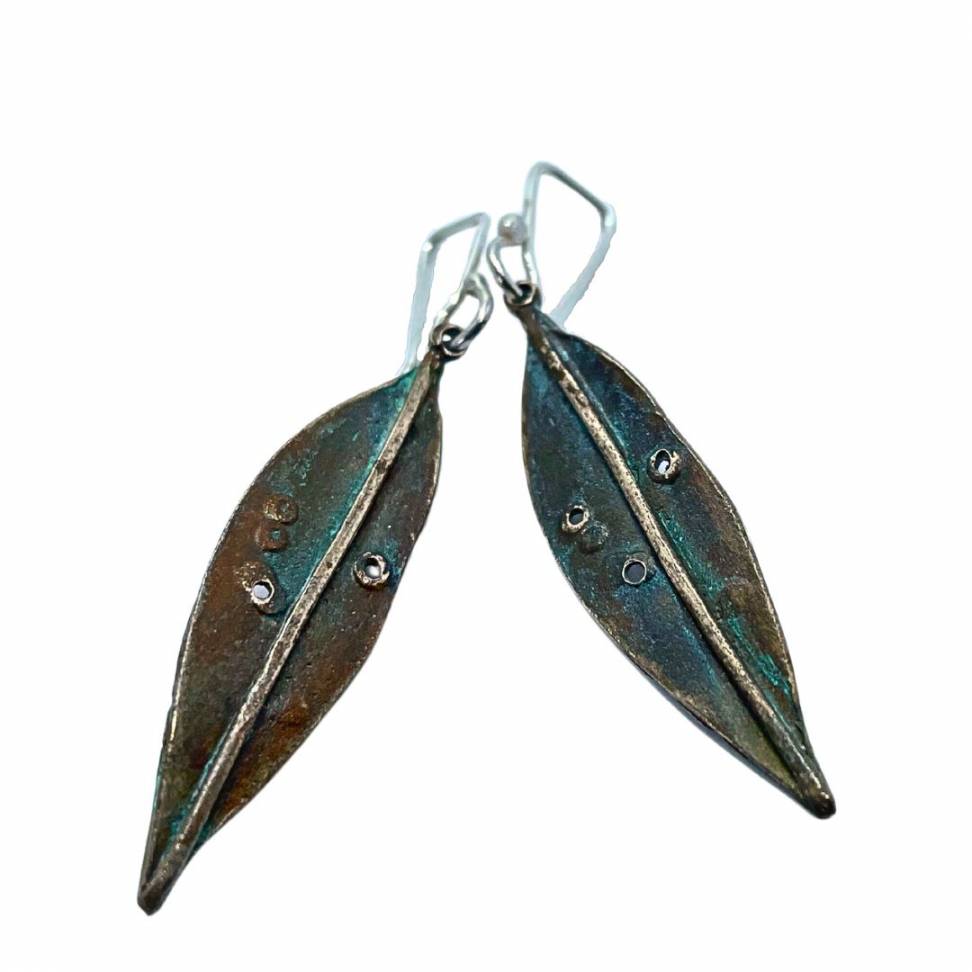 A pair of Bronze Pohutukawa Leaf Earrings hung from 925 Sterling Silver ear hooks